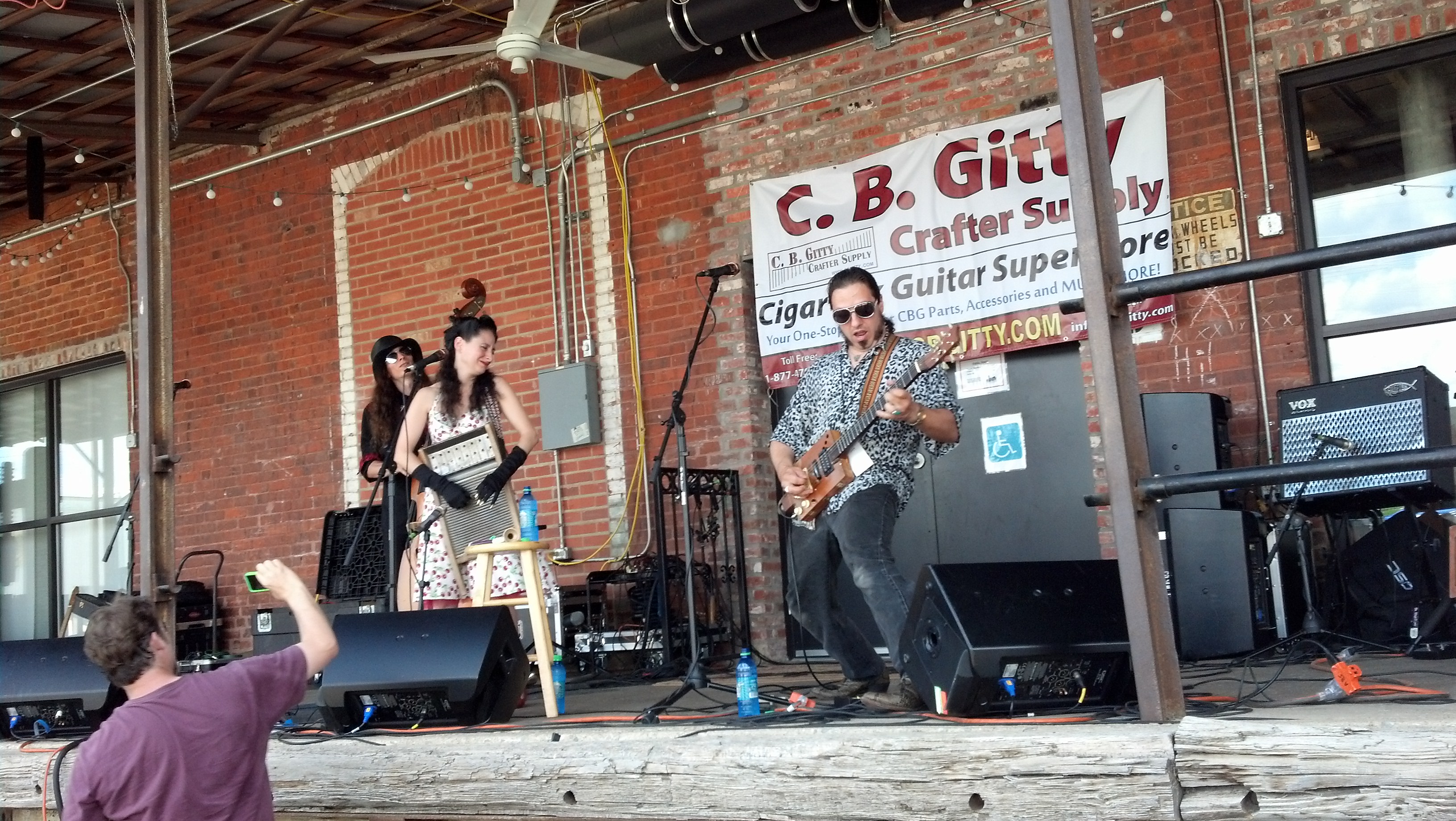 Justin Johnson joins April Mae and the Junebugs as a stand-in upright bassist, while Bill Jehle, of "One Man's Trash" and Cigar Box Guitar Museum fame, tries his hand at photography, lower left.