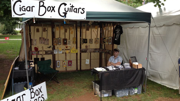 Shane Speal's cigar box guitar vending tent at a festival
