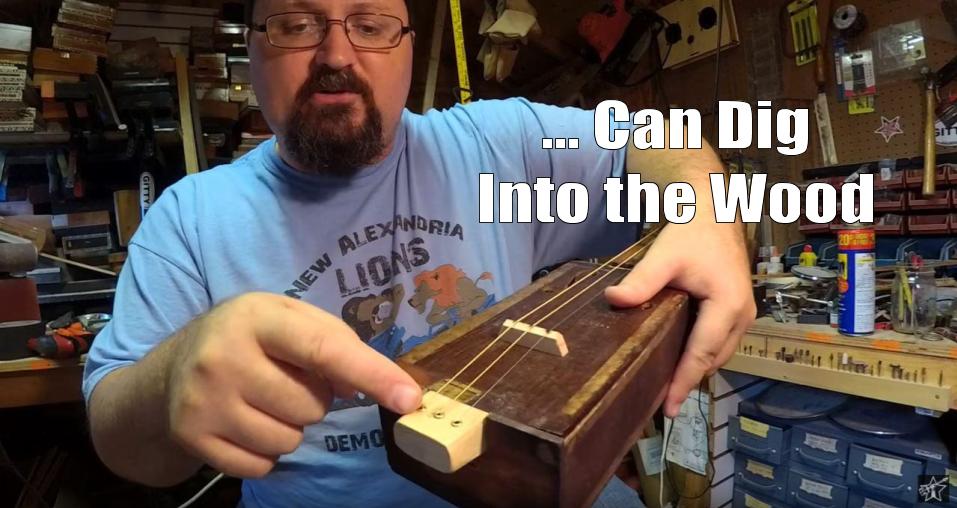 Shane Speal points to strings installed in the tail-end of a cigar box guitar neck