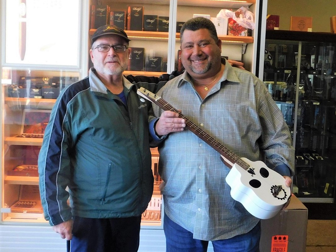 Steve W. and friend holding unique skull 3-string guitar