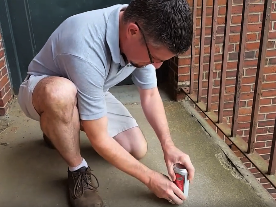 Ben drags the can across the concrete