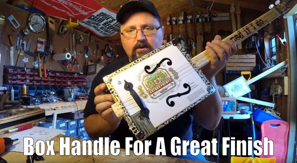 Shane Speal displays a box handle centered on a cigar box guitar