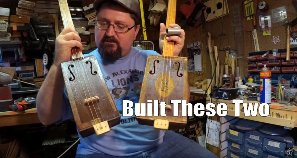 Shane Speal displays two guitars he built using antique cigar boxes