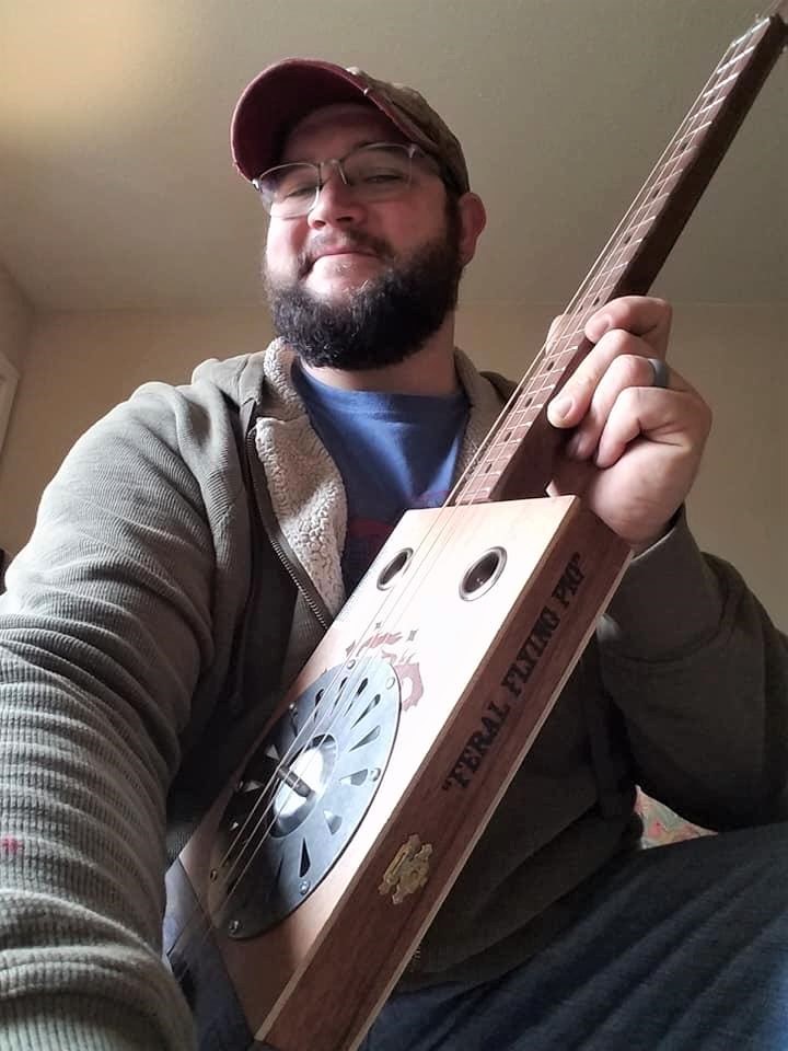 Casey M. of Flying Pig Guitars holding a resonator CBG