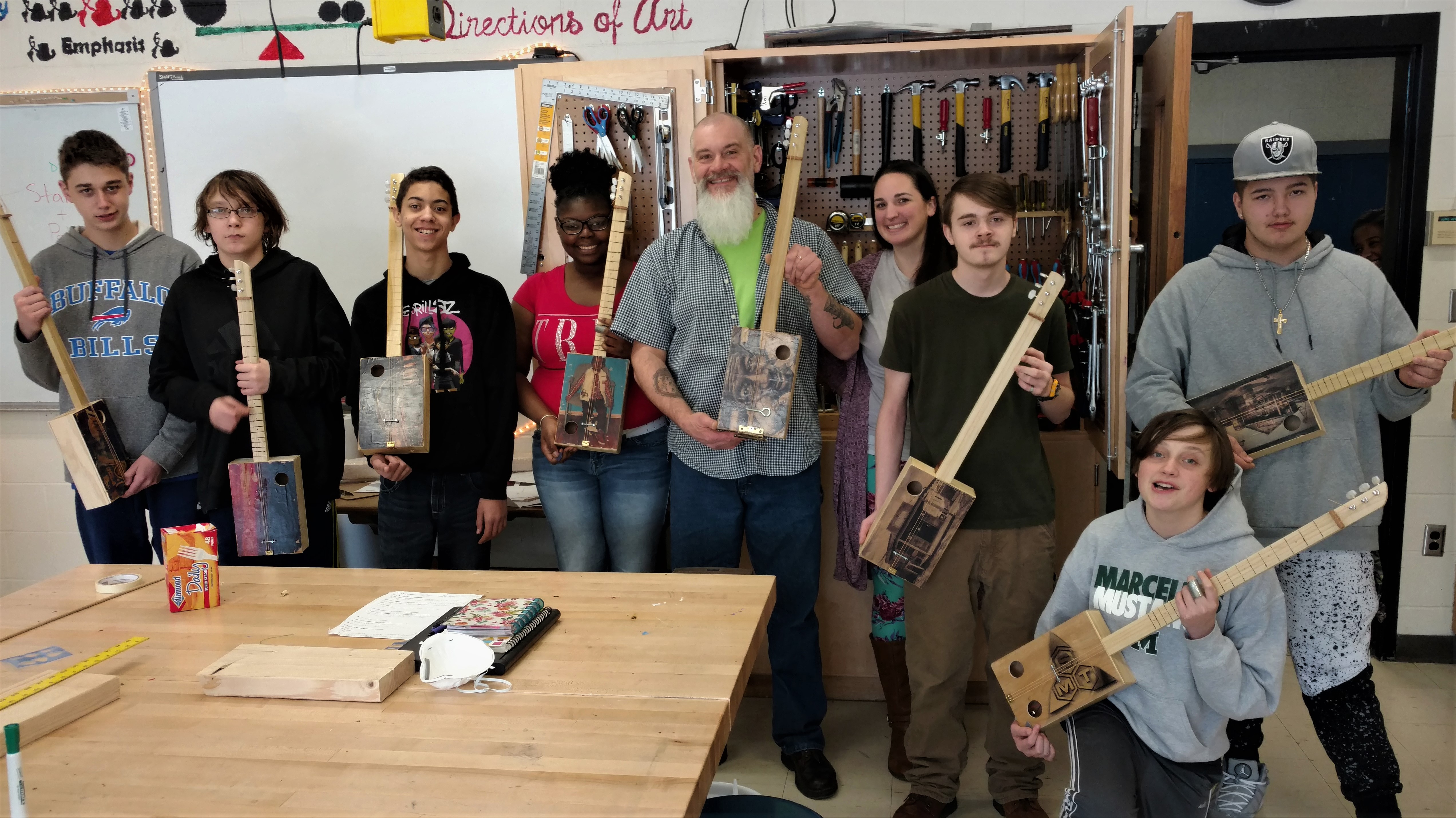Educator Mr. Tracy H. with students and cigar box guitars