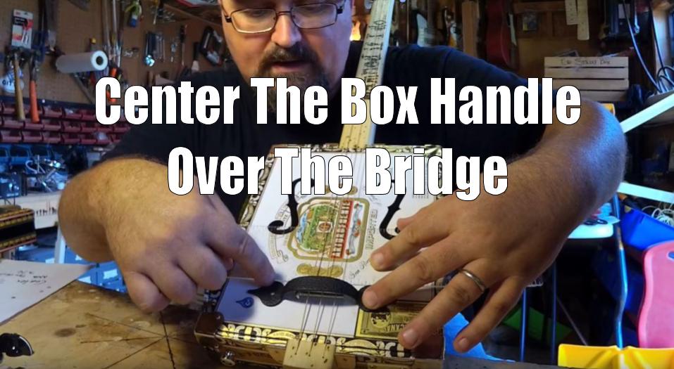 Shane Speal centers a box handle over a cigar box guitar bridge