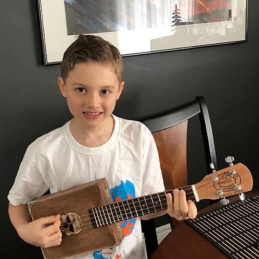 Charles H.'s son holding the ukulele they built together