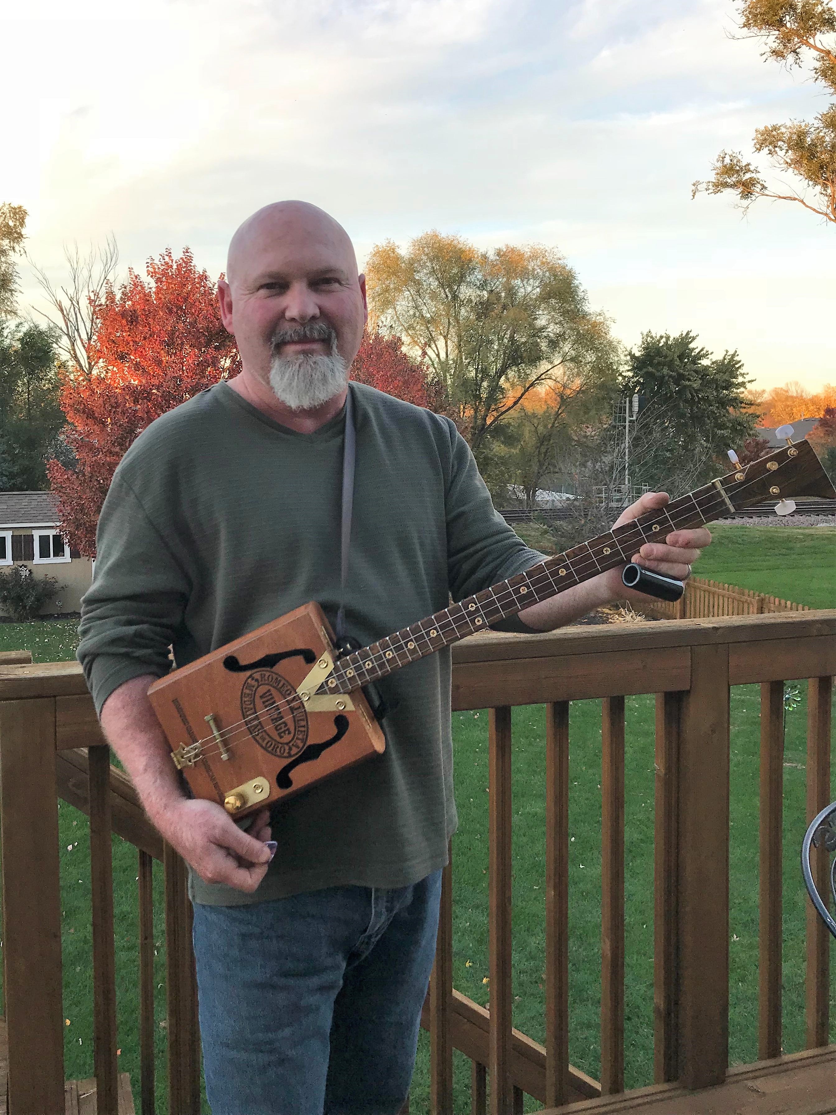 Daniel G. holding the first cigar box guitar he built