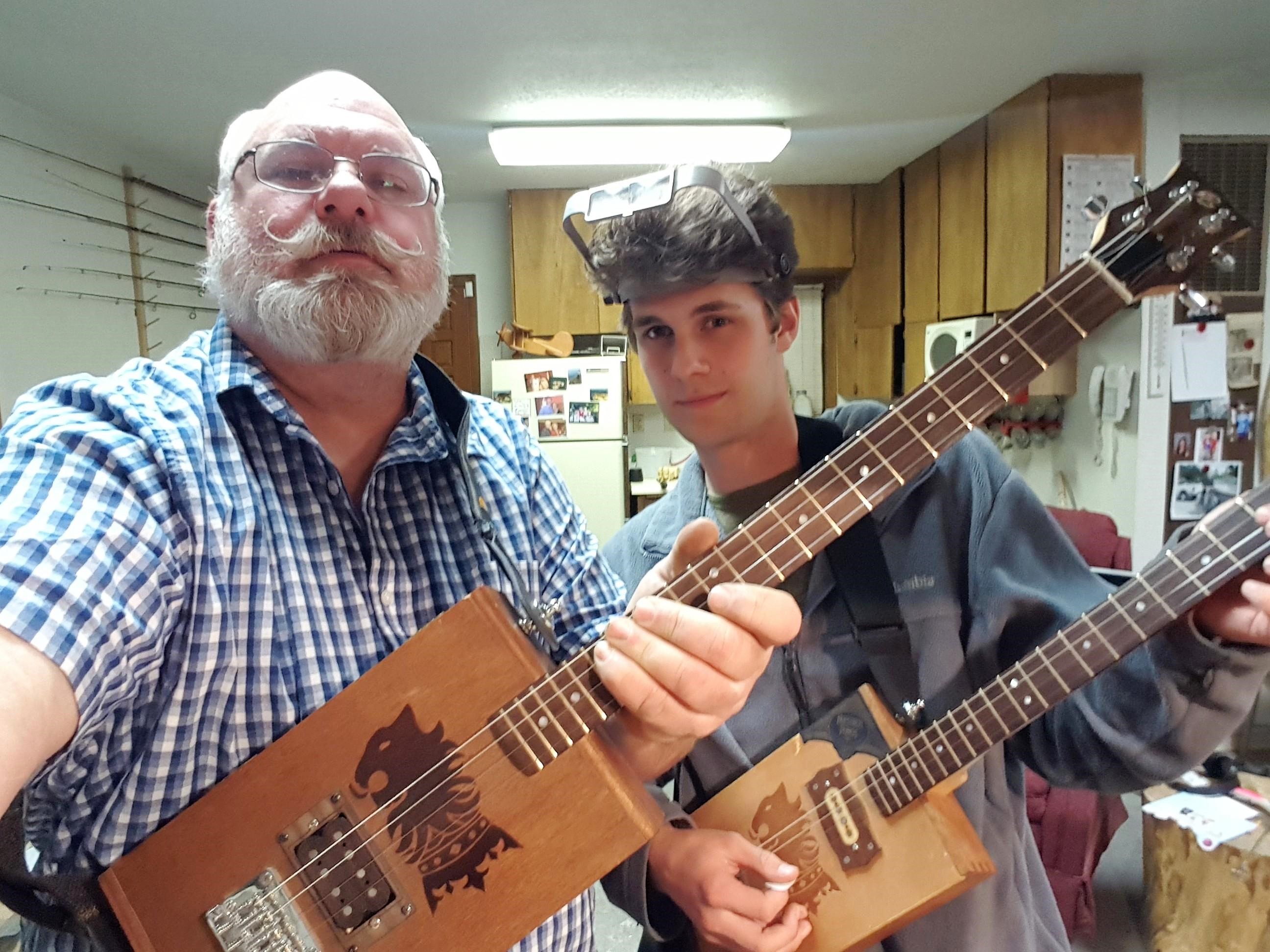 Roy B. and student holding cigar box guitars