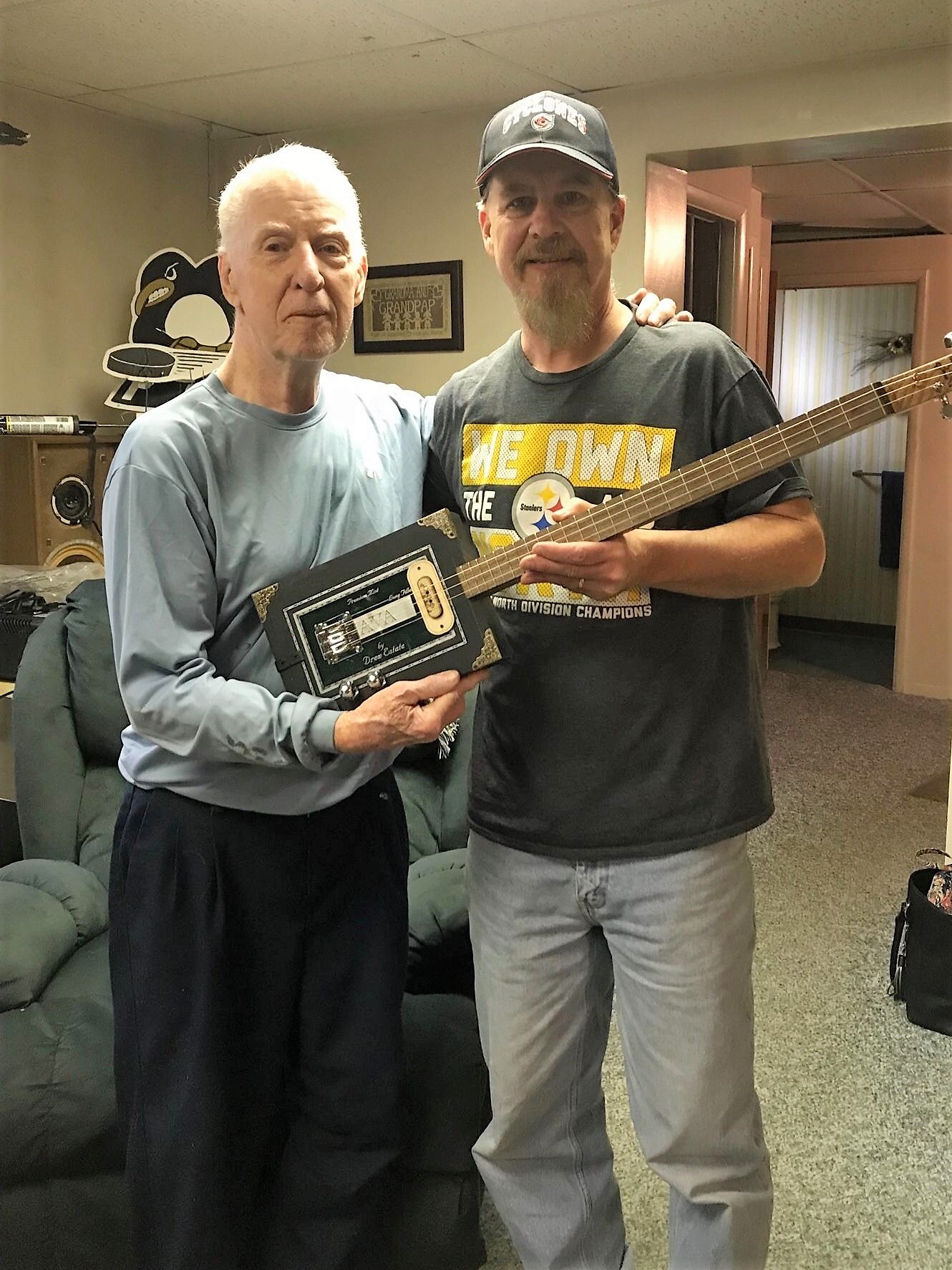 Scott M. and his dad holding the first cigar box guitar they've built together