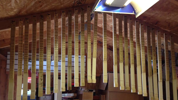 A batch of cigar box guitar necks hanging in Shane Speal's workshop