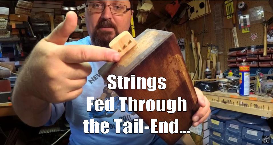 Shane Speal points to strings fed through the bottom of a cigar box guitar neck