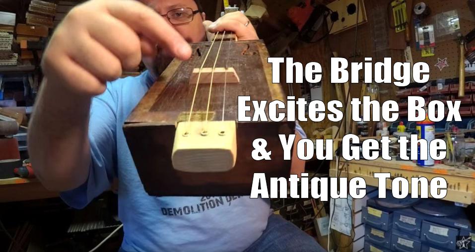 Shane Speal points to a hardwood bridge on a antique-cigar box guitar